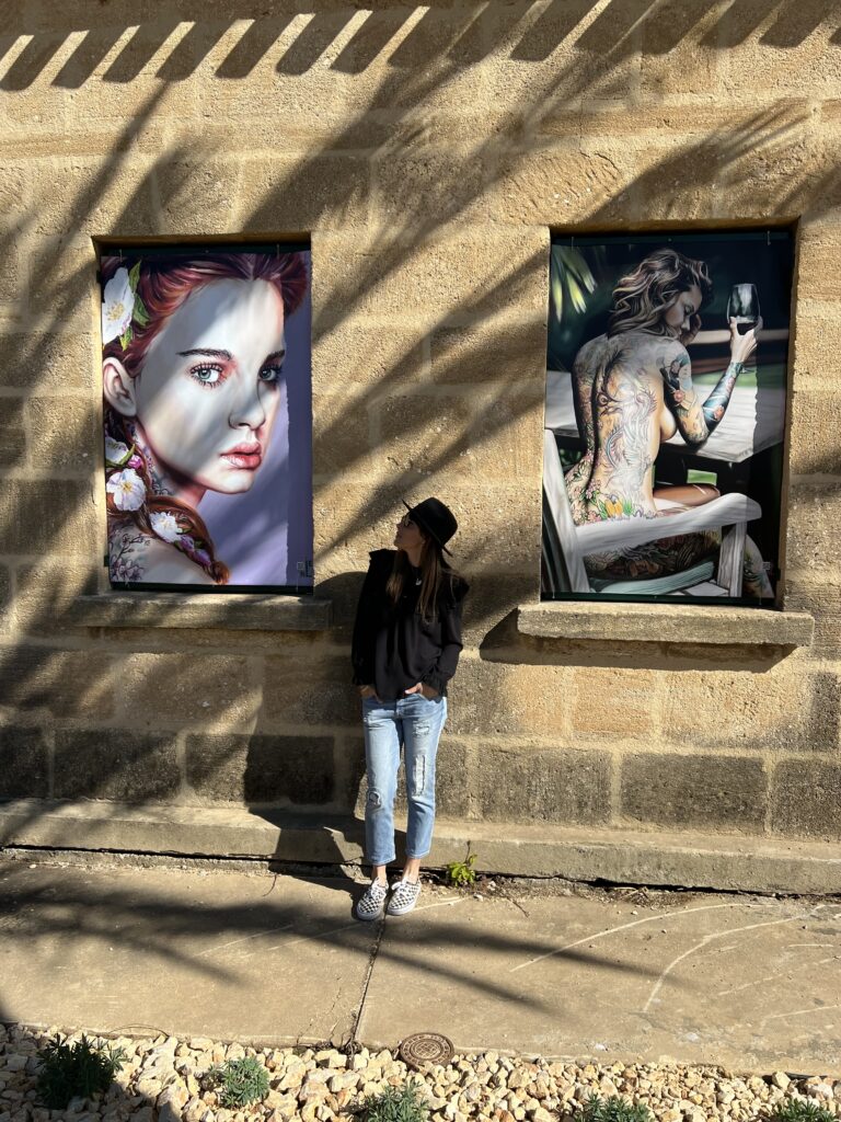 Léni Whitford devant des impressions de ses oeuvres affichées en plein air "Spring" et "La Femme Tatouée" pour la semaine des droits des femmes